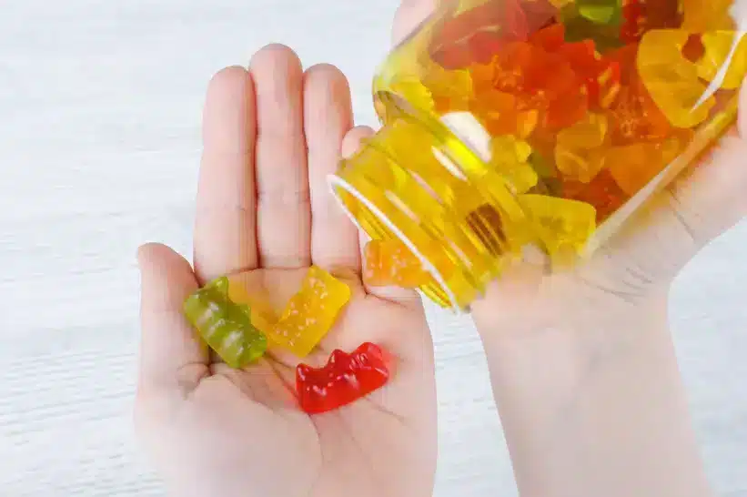 Poured CBD gummies from a bottle over a palm
