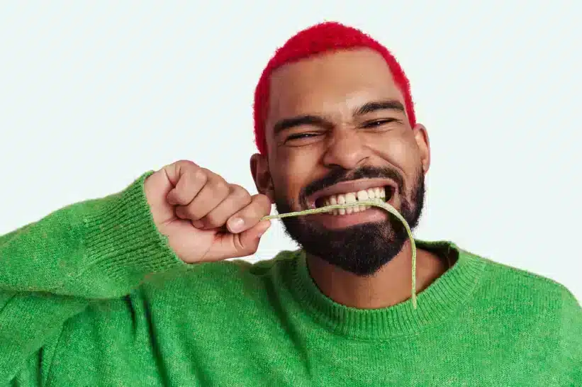 Guy eating a stringy edible or gummy