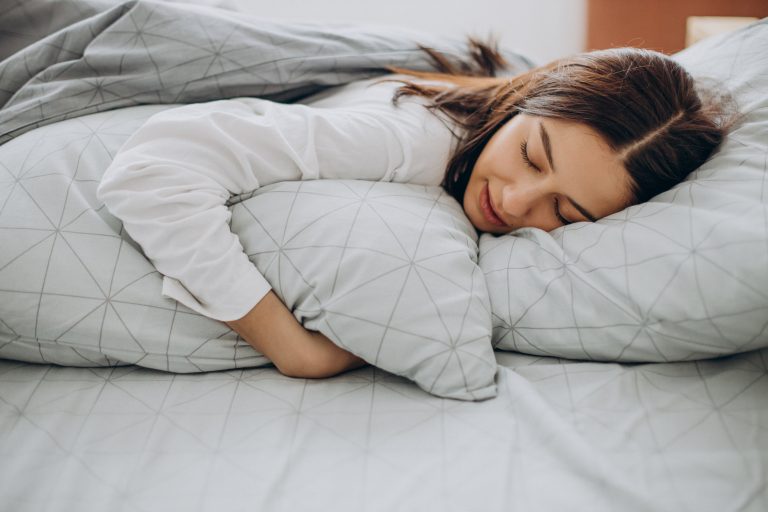 Young women comfortably sleeping in her bed