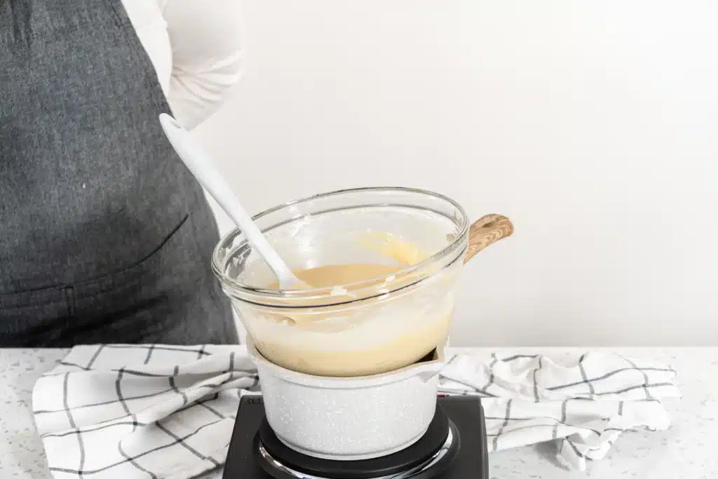 A glass dish filled with milk sitting on top of a boiling pot