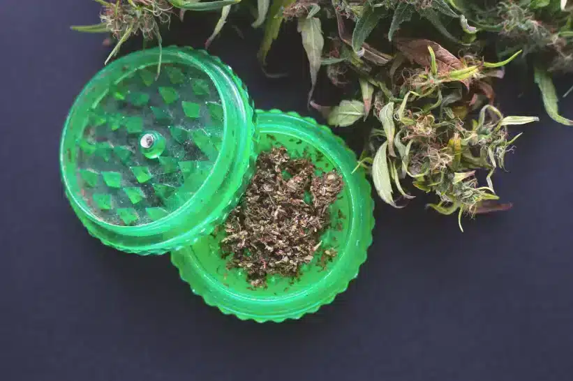 Neon-green plastic herb grinder with bits of hemp flower