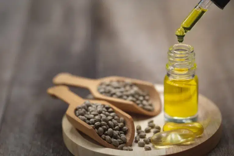 Wooden spoons with hemp seeds and a bottle of CBD oil