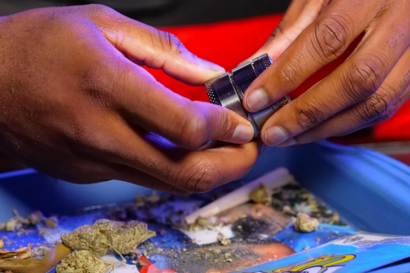 a person holding a weed grinder