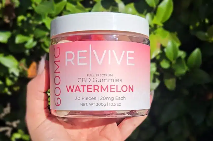 a hand holding a jar of watermelon