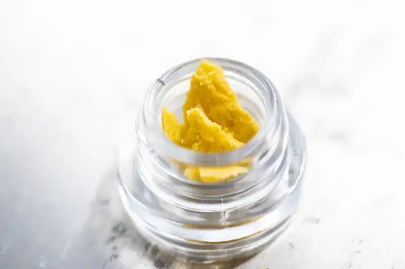 a small glass jar with a THCA concentrate inside
