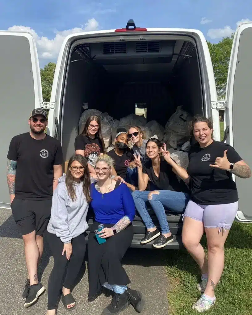 a group of people posing in the back of a van