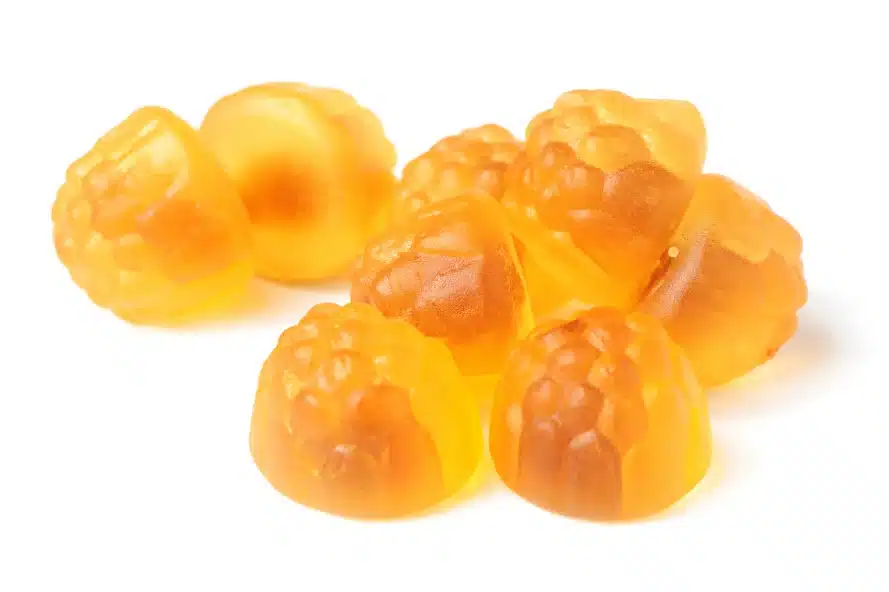 Yellow discolored CBD gummy candies shaped like raspberries