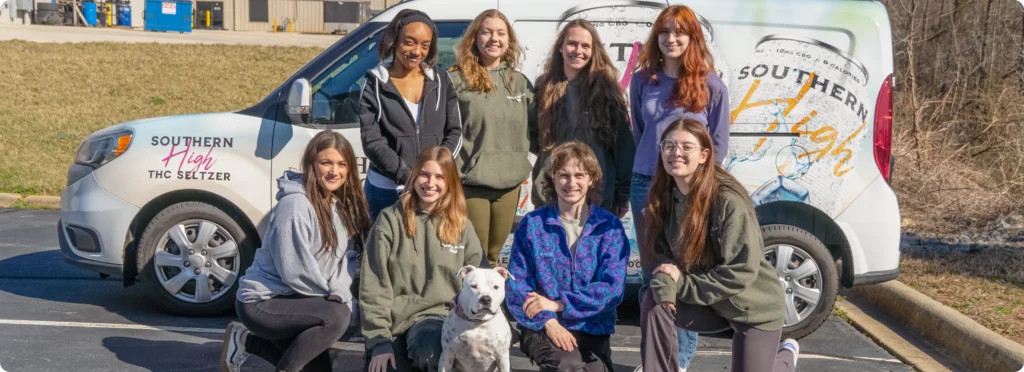 The Hemp Doctor team gathered with a white dog in front of the company delivery van