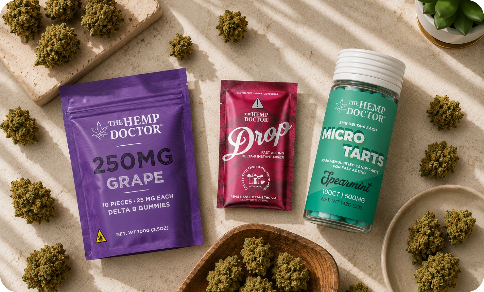 The Hemp Doctor 250mg Grape Delta 9 gummies, a Drop fast-acting mixer and a jar of Spearmint Micro Tarts beside hemp flower buds