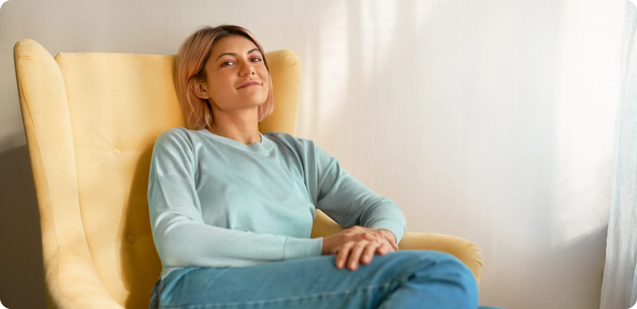 Woman relaxing in a yellow armchair