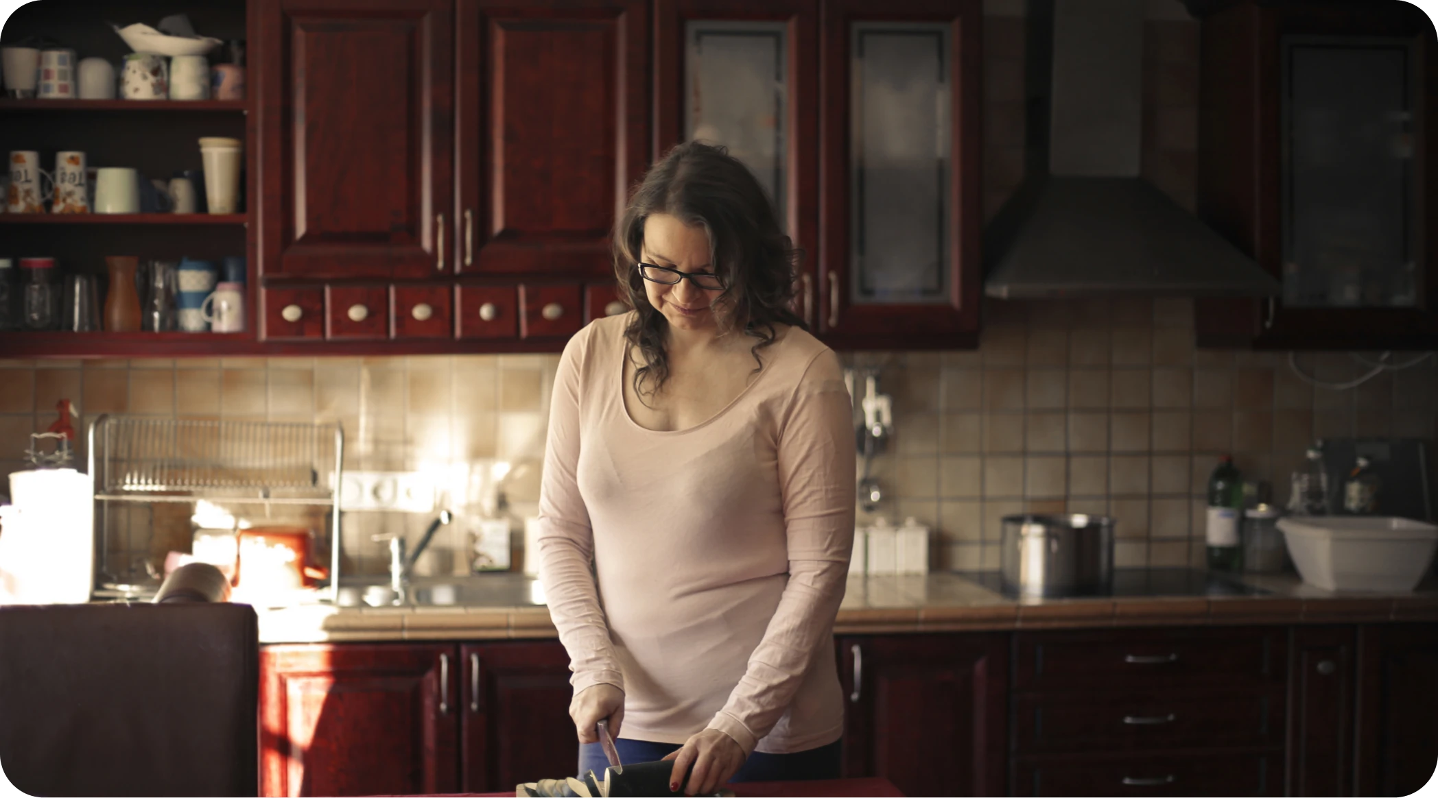A woman preparing a drink in her kitchen