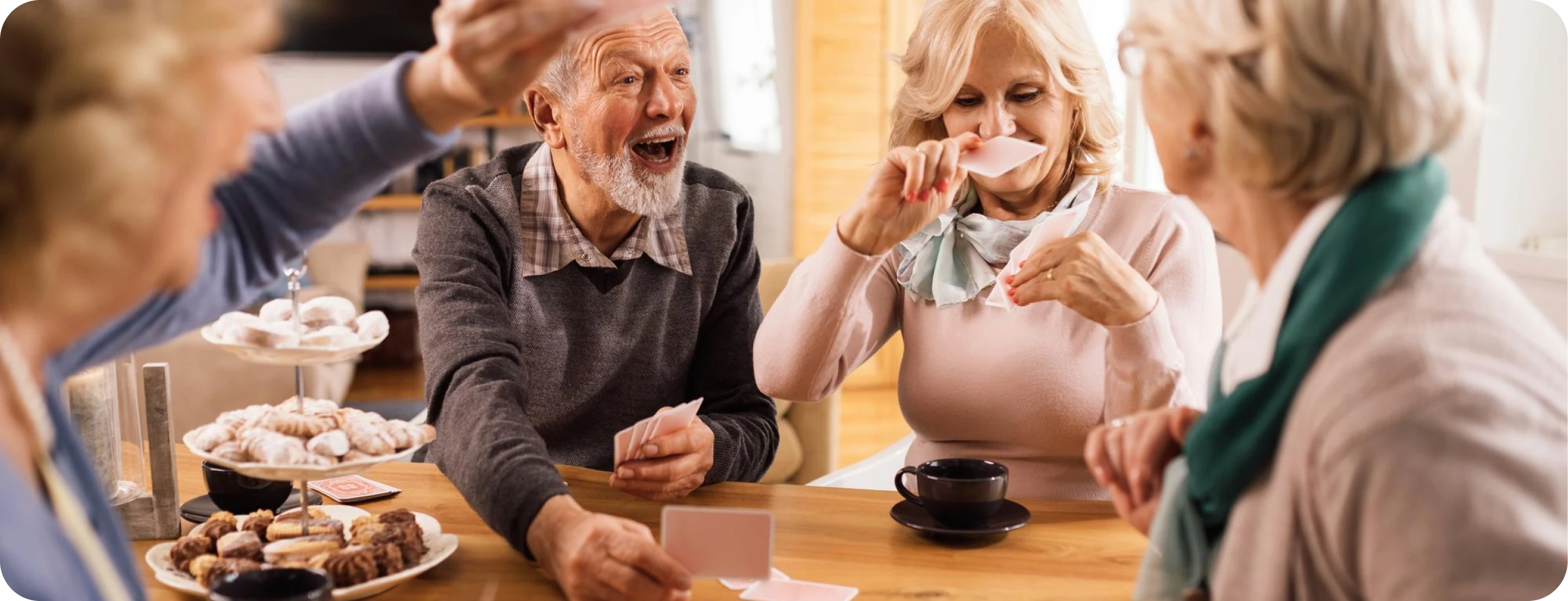 Older friends laughing together around a table